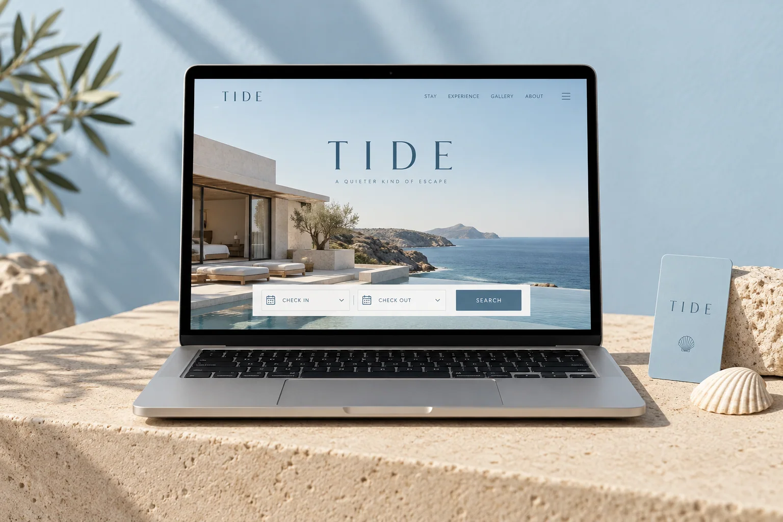 Fiktives Hotel TIDE: Website-Entwurf auf einem Laptop mit hellblauer Zimmerkarte und Muschel